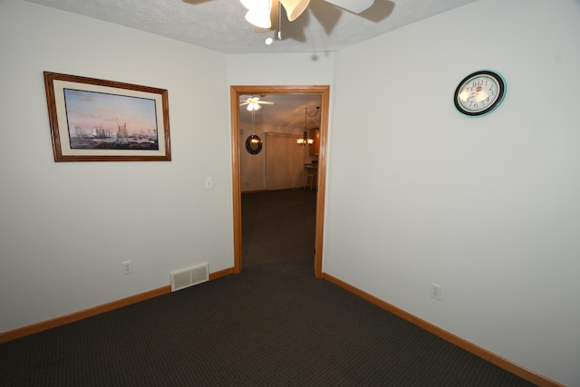 empty room featuring ceiling fan, a textured ceiling, and carpet floors