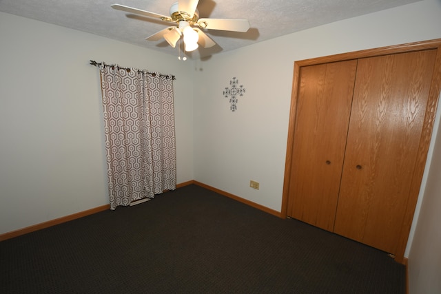 unfurnished bedroom featuring a textured ceiling, carpet floors, ceiling fan, and a closet