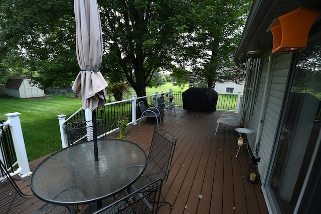 wooden deck with a yard and a storage shed