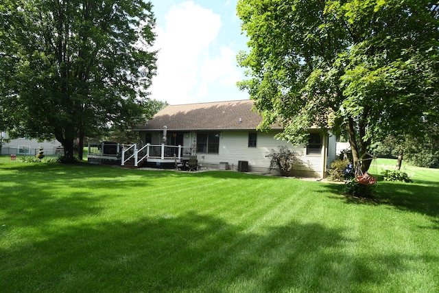 rear view of property with a lawn and a deck