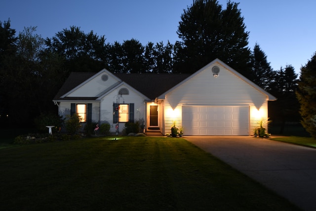 ranch-style house featuring a garage and a lawn