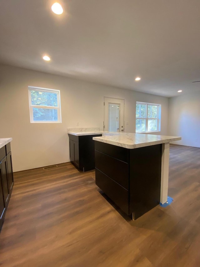 kitchen with a kitchen island and dark wood-type flooring