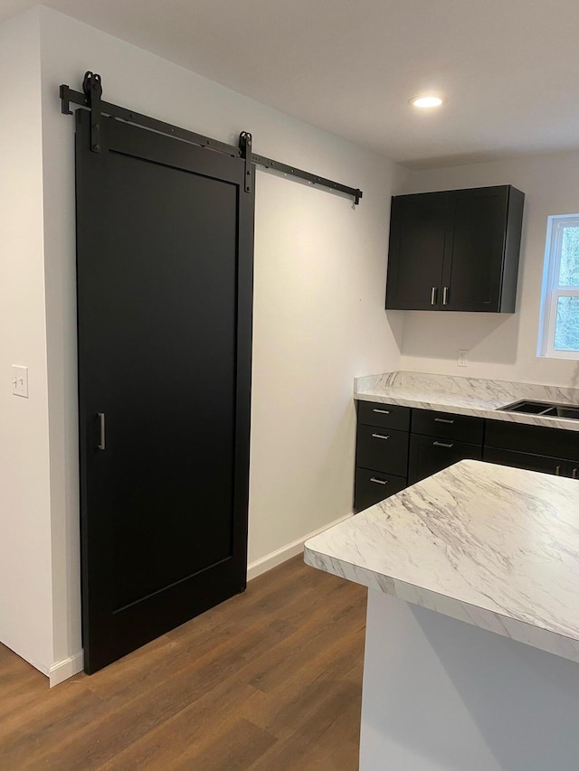 kitchen featuring a barn door, dark hardwood / wood-style flooring, and sink