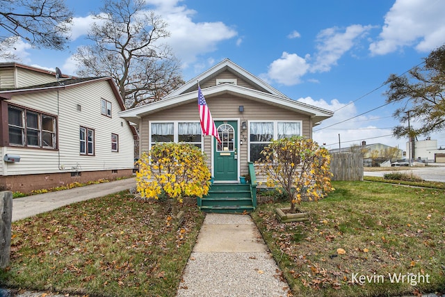 bungalow-style home with a front yard