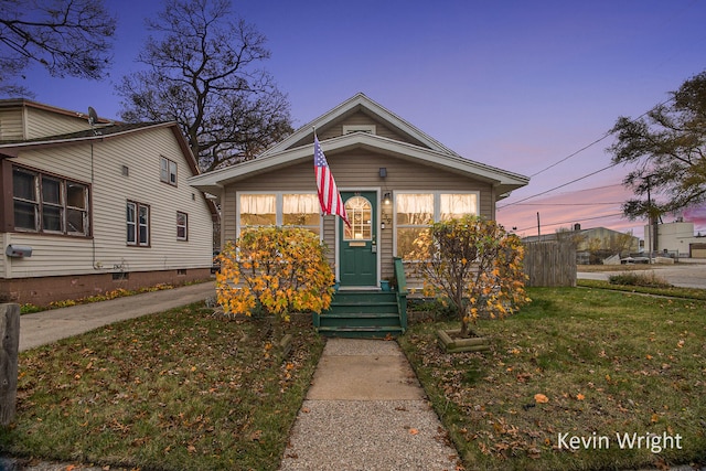 bungalow-style house featuring a lawn