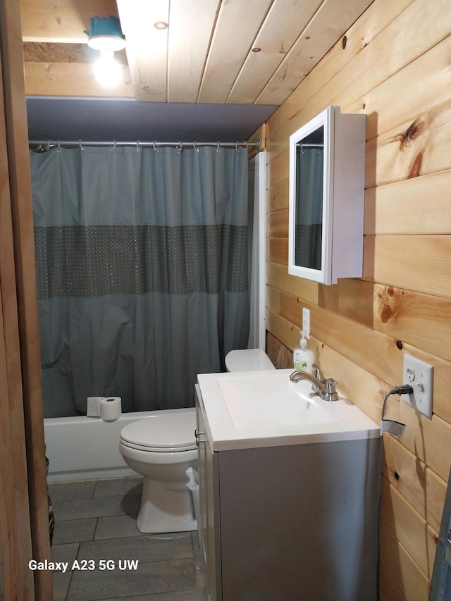 full bathroom with vanity, shower / bath combo with shower curtain, toilet, and wood walls