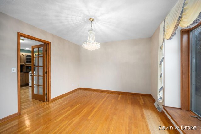 empty room with a chandelier and wood-type flooring