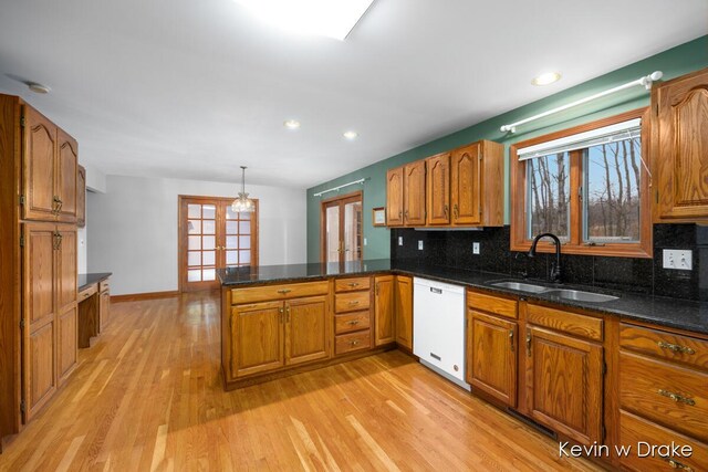 kitchen featuring dishwasher, a healthy amount of sunlight, kitchen peninsula, and sink