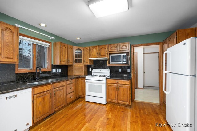 kitchen featuring decorative backsplash, sink, white appliances, and light wood-type flooring