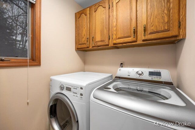 laundry room featuring separate washer and dryer and cabinets