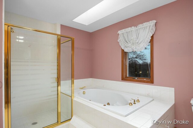 bathroom featuring toilet, shower with separate bathtub, and a skylight