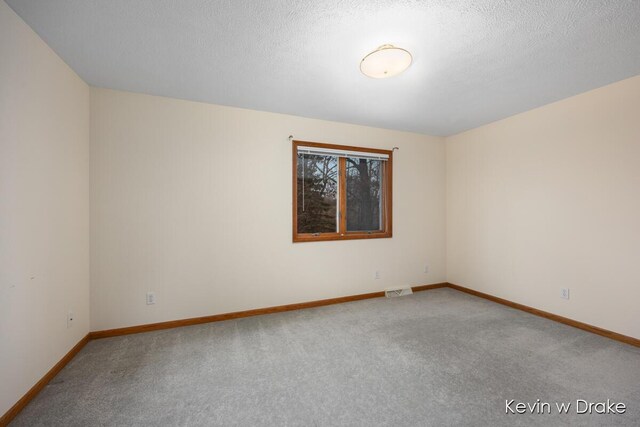 carpeted spare room featuring a textured ceiling