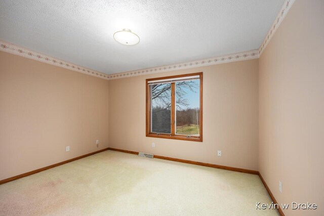 carpeted empty room with a textured ceiling