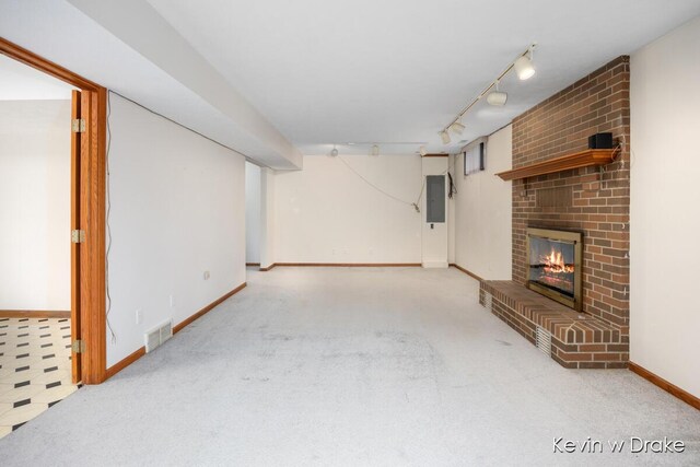 unfurnished living room with light carpet, rail lighting, electric panel, and a brick fireplace