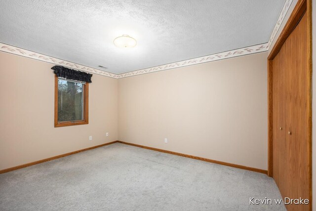 unfurnished bedroom featuring carpet flooring, a closet, and a textured ceiling