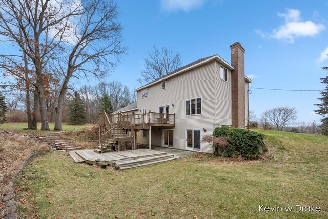 back of property with a lawn and a deck