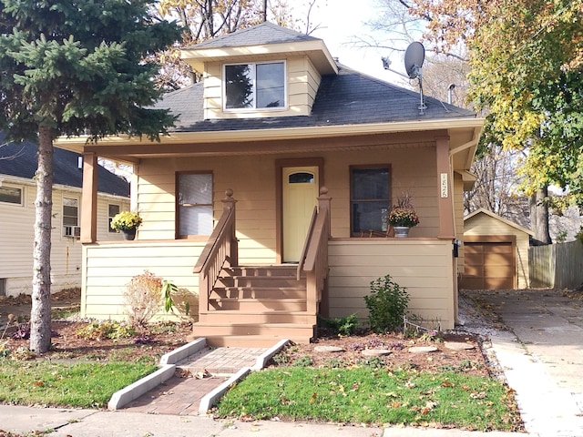 bungalow-style home with a porch, an outbuilding, and a garage