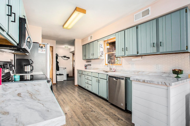 kitchen featuring backsplash, stainless steel appliances, dark wood-type flooring, and sink