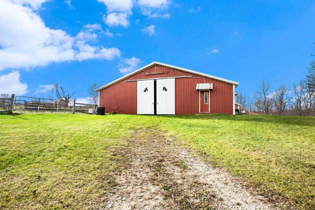 view of outbuilding featuring a lawn and a rural view