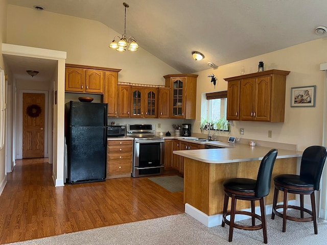 kitchen with black appliances, sink, lofted ceiling, and hardwood / wood-style floors