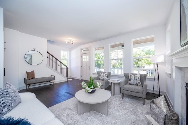 living room with dark hardwood / wood-style flooring and a healthy amount of sunlight