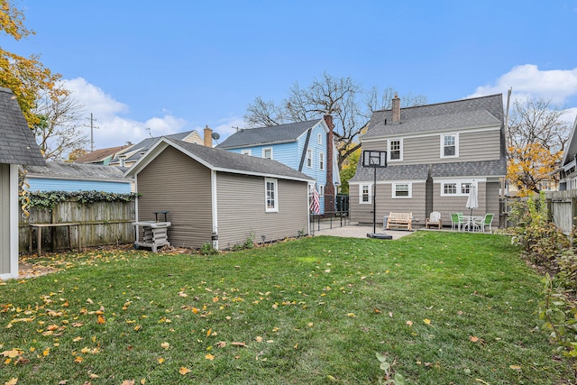 rear view of house featuring a yard and a patio