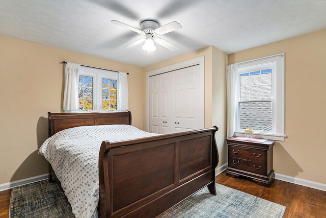 bedroom with a textured ceiling, ceiling fan, a closet, and dark hardwood / wood-style floors