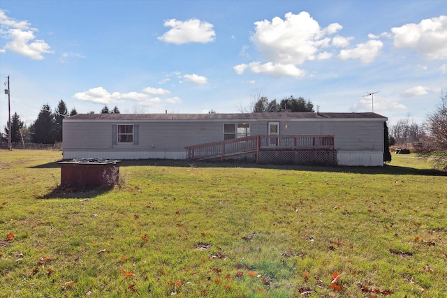 rear view of house featuring a lawn and a wooden deck