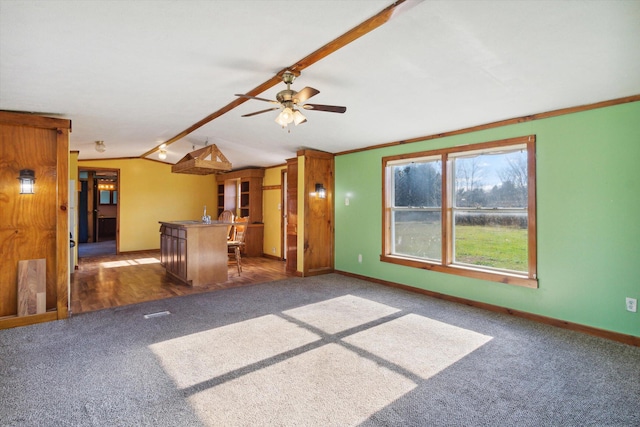 unfurnished living room with ornamental molding, lofted ceiling, dark hardwood / wood-style flooring, ceiling fan, and bar