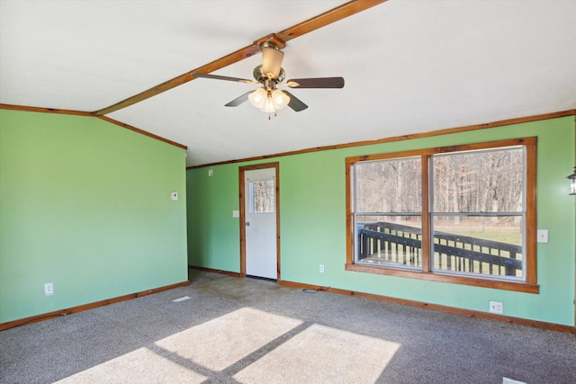 empty room featuring vaulted ceiling, carpet, ceiling fan, and crown molding