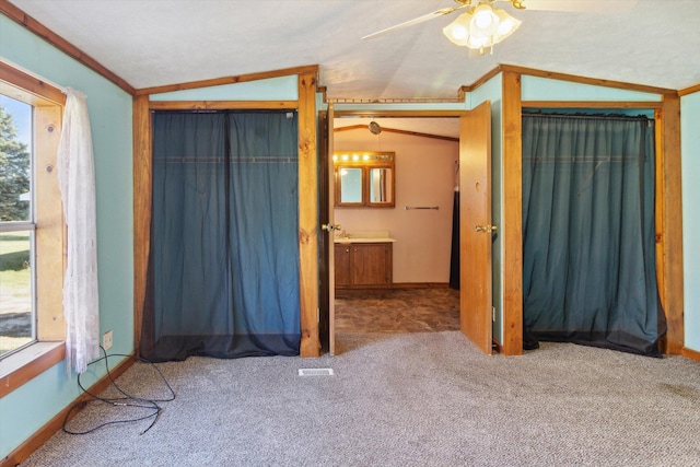 unfurnished bedroom featuring vaulted ceiling, ornamental molding, ceiling fan, and multiple windows