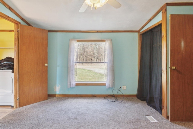 unfurnished bedroom with vaulted ceiling, a closet, washer / clothes dryer, ceiling fan, and light carpet