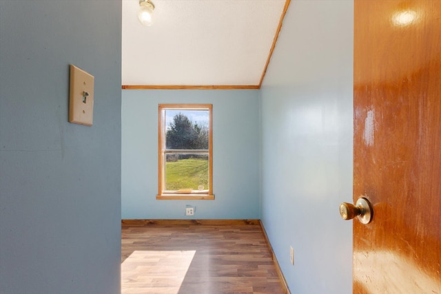 unfurnished room featuring wood-type flooring and crown molding