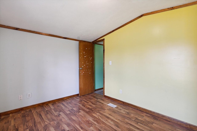 empty room featuring ornamental molding, dark hardwood / wood-style flooring, and lofted ceiling