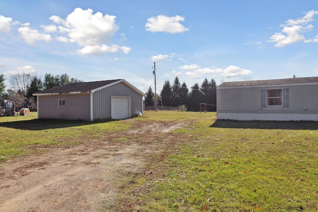 view of yard featuring a garage and an outdoor structure