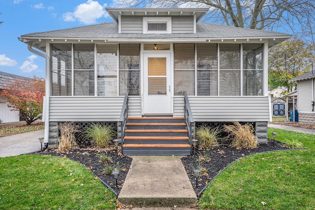 bungalow-style house featuring a front yard and a sunroom