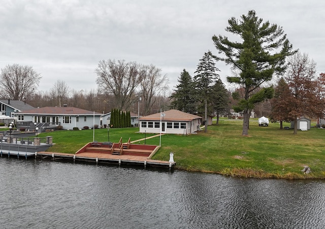 dock area featuring a water view and a lawn