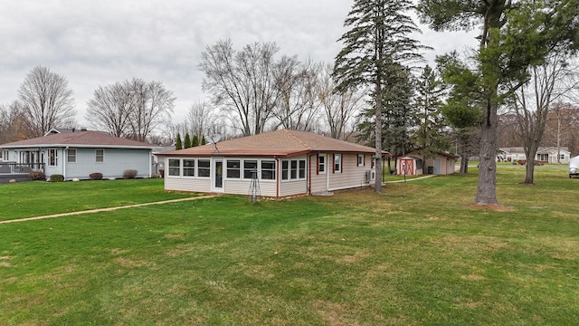 back of property with a lawn and a sunroom