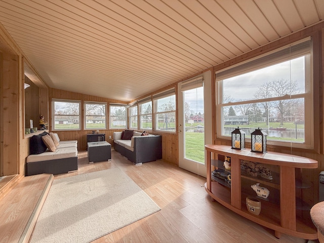 sunroom / solarium with a water view, lofted ceiling, and wood ceiling