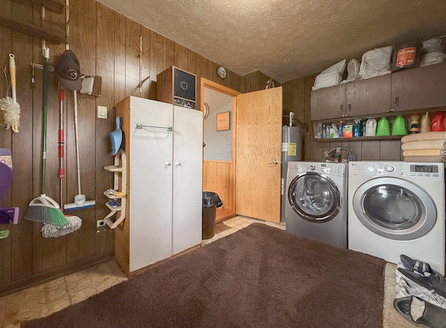 laundry room with a textured ceiling, separate washer and dryer, and wood walls