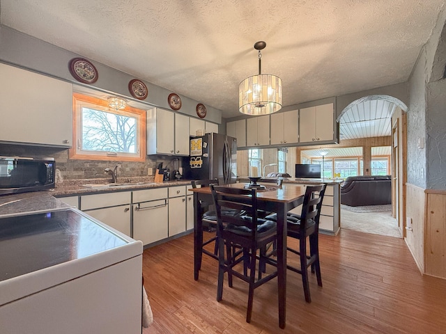 kitchen with light hardwood / wood-style flooring, white cabinets, and pendant lighting