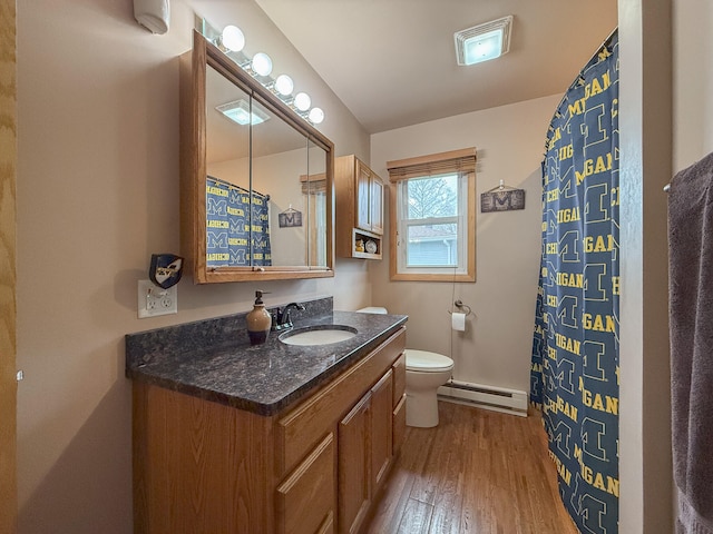 bathroom with hardwood / wood-style floors, vanity, toilet, walk in shower, and a baseboard radiator