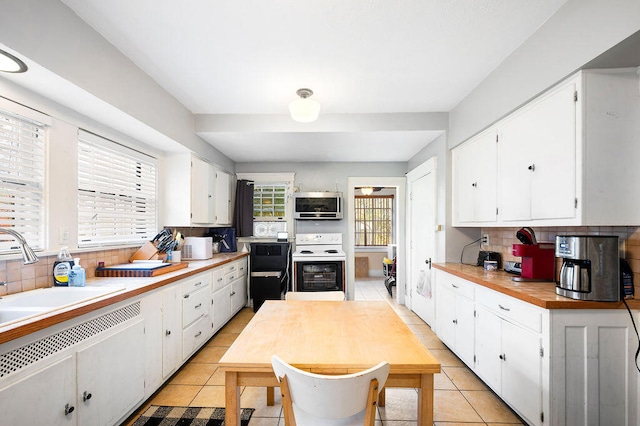 kitchen featuring a wealth of natural light, white cabinetry, and tasteful backsplash