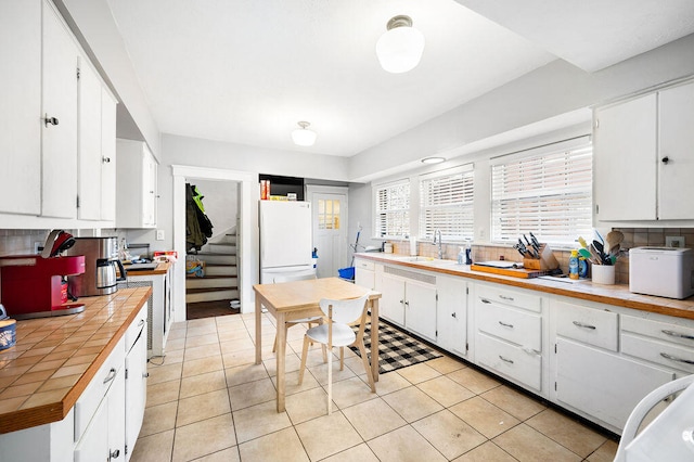 kitchen with white cabinets, sink, tasteful backsplash, and white fridge