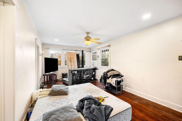 bedroom featuring dark hardwood / wood-style flooring, ornamental molding, and ceiling fan