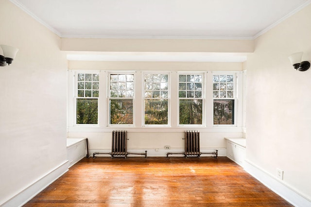 spare room featuring ornamental molding, radiator heating unit, and light hardwood / wood-style floors