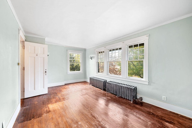 spare room featuring hardwood / wood-style floors, plenty of natural light, and ornamental molding