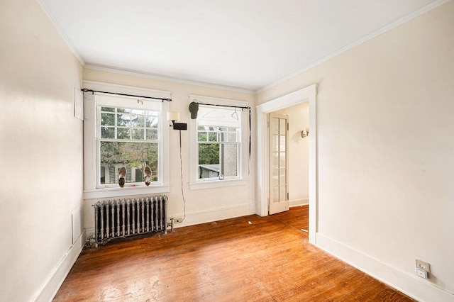 unfurnished room with radiator heating unit, hardwood / wood-style floors, and ornamental molding