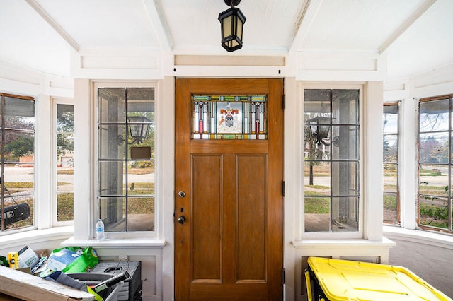 foyer with a wealth of natural light and vaulted ceiling with beams