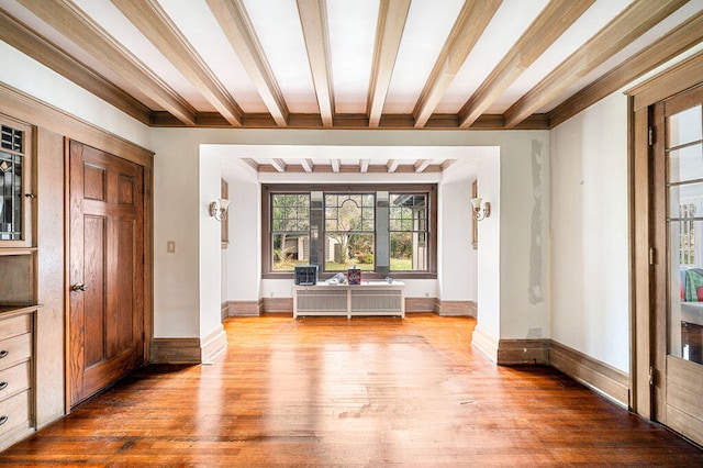 interior space with hardwood / wood-style flooring and beam ceiling